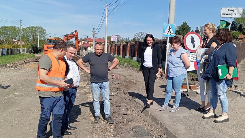 Powiększ: Osoby stojące na rozkopanej ulicy w przewbudowie.